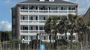 Un hotel de varios pisos con balcones, vista al mar y un letrero que indica zona de acceso restringido.