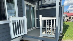 Ein Haus mit Veranda, einer Schiebetür und einer kleinen Treppe, die zum Eingang führt.