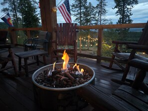 A wooden deck with a fire pit, chairs, and an American flag. - Winter Park-The Mango Lodge-6000sf Log Home- (Tabernash)