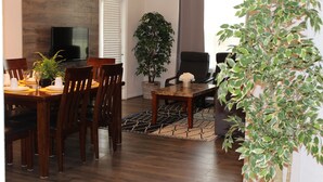 A dining area with a wooden table, chairs, a TV, and a potted plant. - VC210 - Universal, Sea World, Convention Center (Orlando)