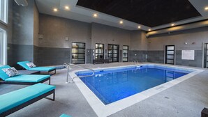 An indoor swimming pool with lounge chairs and a ceiling with recessed lighting. - NEW Aura Newly built and spacious 2 bed, 2 bathrooms (Regina)