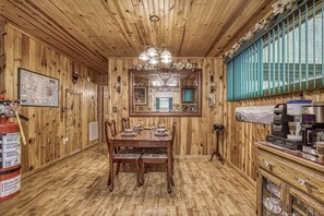 Cozy retreat with a wooden dining table, coffee station, and wall-mounted map.