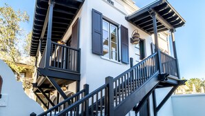 A two-story building with a balcony and a staircase. - ROSEMARY BEACH - South of 30A - Abaco on the Green Carriage House (Panama City Beach)