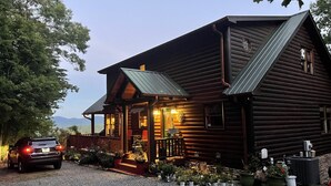 A log cabin with a porch, a car parked in front, and potted plants around the entrance. - July4-7OPEN50%OFF❤️BESTMountainView/Hot Tub/ Pool Table  /Ping Pong Table/ Wifi  (Blue Ridge)