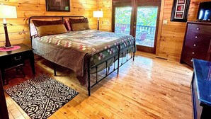 A wooden cabin bedroom with a bed, a desk, a dresser, and a ceiling fan. - July4-7OPEN50%OFF❤️BESTMountainView/Hot Tub/ Pool Table  /Ping Pong Table/ Wifi  (Blue Ridge)