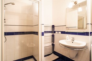 A bathroom with a shower, sink, and mirror.