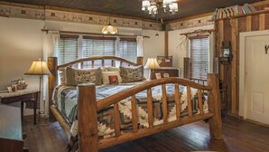 A traditional bedroom with a wooden bed, two bedside lamps, a desk, and a chair. - Prairie House. River Cabin. Sleeps 8 (Glen Rose)