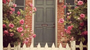 A brick house with a dark grey door, flanked by two windows with shutters. - 1870's Luxury Guest Cottage, Historic Downtown St. Charles, Mo. (St. Charles)