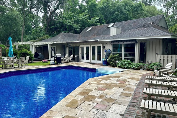 Rear view of home with fenced back yard and pool