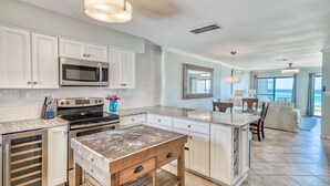 A modern kitchen with white cabinetry, stainless steel appliances, and a central island.