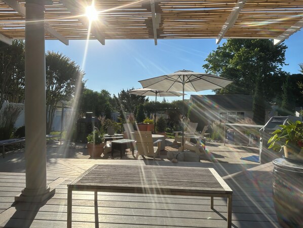 Un patio abrité avec une table, des chaises et un parasol.