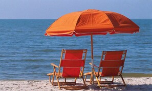 Una playa cerca, sillas reclinables de playa, toallas de playa