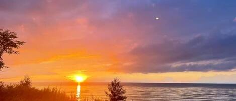 Ein Sonnenuntergang über einem Gewässer mit klarem Horizont.