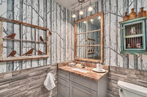 A bathroom with a wooden vanity, a sink, a mirror, and a toilet. - Luxury 4 King Bdrm, 4.5 Bth, Pavilion; Fire Place, TV, Waterfall, Fire Pit (Asheville)