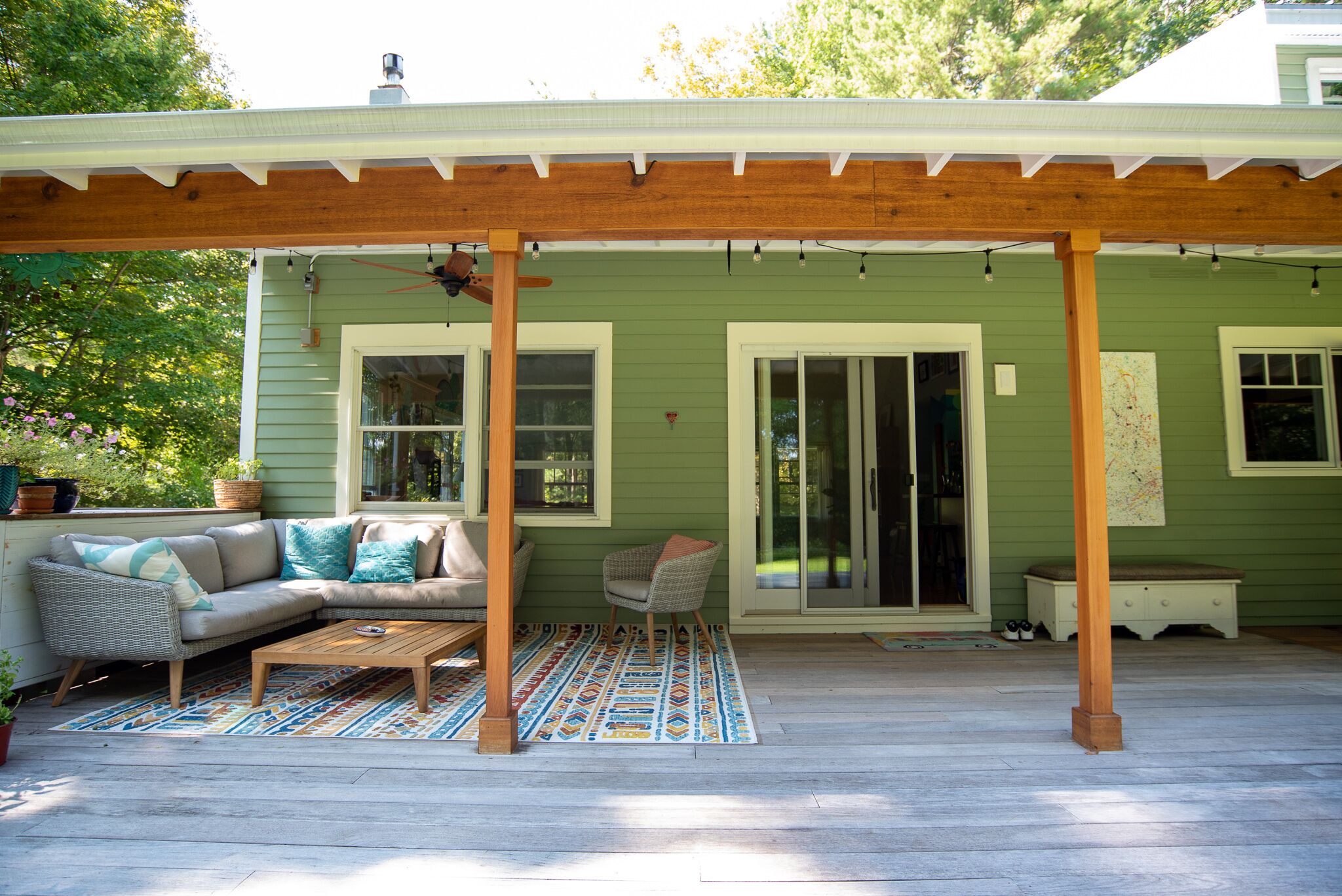 A covered patio with a sofa, chairs, and a coffee table.