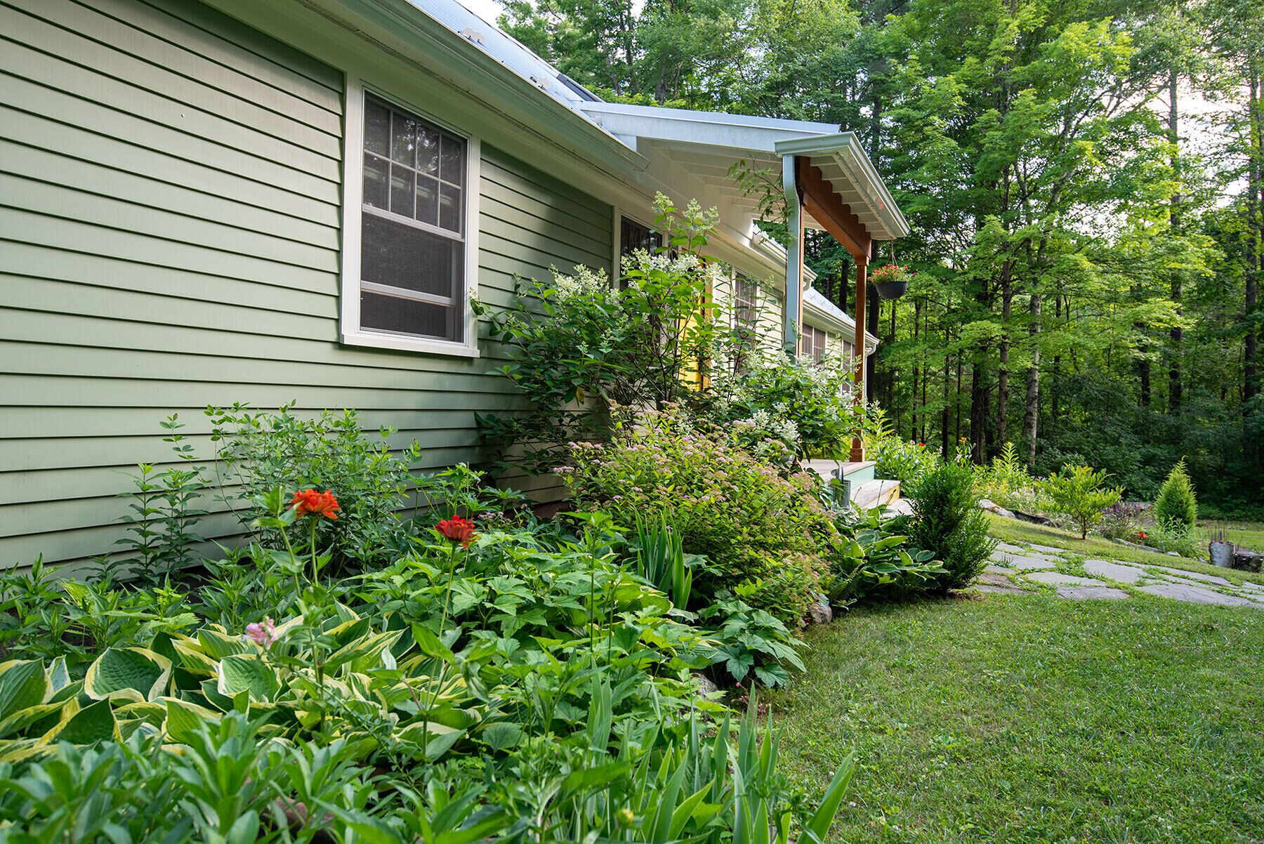 A house with a covered porch and a well-maintained garden.