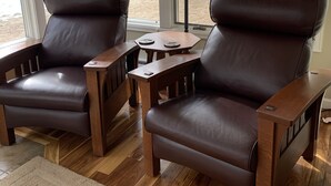 A room with two leather armchairs, a small wooden table, and a floor lamp. - Beautiful river home with large yard, sitting area and fire pit! (Estes Park)