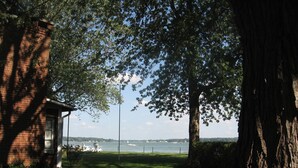 A park with a brick building, a bench, and a large tree. - Macatawa Lake View Cottage by State Park and Bike Trails (Holland)