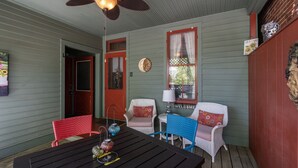 A porch with a table and chairs, a ceiling fan, and a welcome sign. -  SPACIOUS HISTORIC DOWNTOWN LOFT!  BEST LOCATION IN THE HEART OF TOWN! (Hermann)