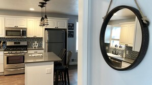 Una cocina moderna con armarios blancos, electrodomésticos de acero inoxidable y un salpicadero blanco y negro.