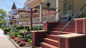A hotel entrance with a red staircase, a flower bed, and a sign for 'The Duffy's'. - Cape May Jackson Street Beach Rental with Ocean Views (Cape May)
