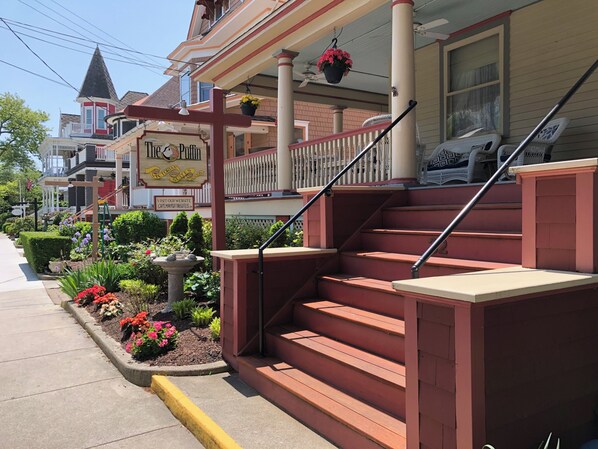 Entrada de hotel con una escalera roja, un parterre y un letrero que dice 'The Duffy's'.