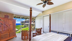 A bedroom with a large bed, wooden furniture, and a view of a lush landscape. - REDUCED July & August!  ~ OCEAN FRONT Bay Villa- 25 G-5 ~ Platinum Maui Vacations (Lahaina)