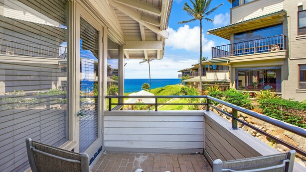 A balcony with a view of the ocean, a palm tree, and a building with a balcony. - REDUCED July & August!  ~ OCEAN FRONT Bay Villa- 25 G-5 ~ Platinum Maui Vacations (Lahaina)