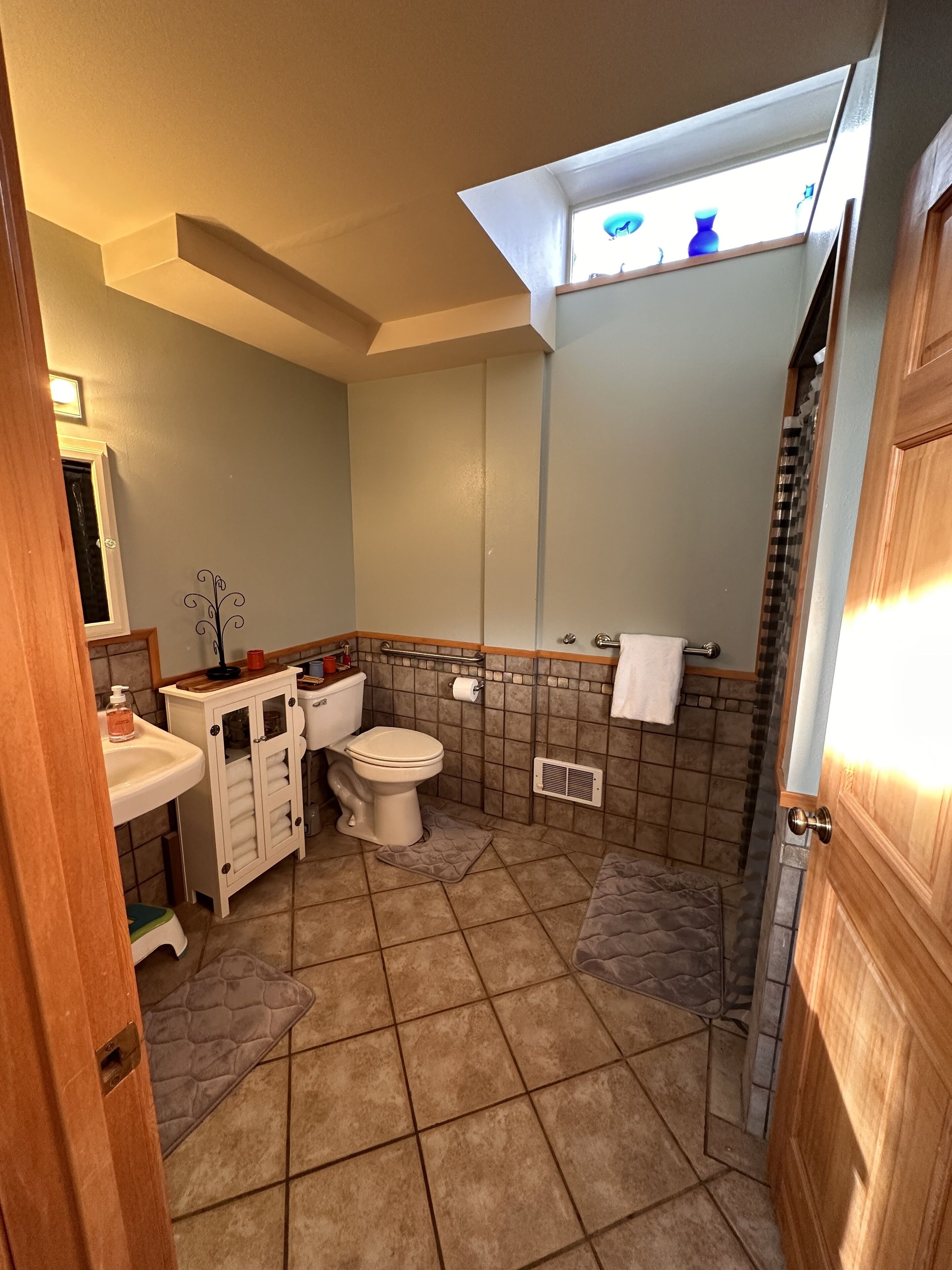 A bathroom with a toilet, sink, and shower.