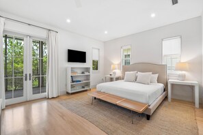 Ein modernes Schlafzimmer mit einem großen Bett, einem Fernseher und einem Bücherregal.