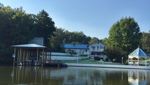 A lakeside property with a dock, a gazebo, and a house with a blue roof. - Glorious gateway 4 bedroom lake home- Discount Rates!! (Hot Springs)