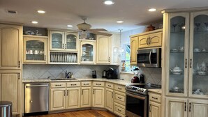 A kitchen with wooden cabinets, a stainless steel dishwasher, a microwave, and an oven. - Glorious gateway 4 bedroom lake home- Discount Rates!! (Hot Springs)