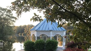 A gazebo with a blue roof and white lattice walls, surrounded by a grassy area and a pathway. - Glorious gateway 4 bedroom lake home- Discount Rates!! (Hot Springs)