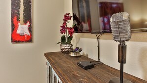 A wooden desk with a microphone, a remote control, and a decorative plant. - Abby's Place 4 - Rocking On Route 66 (Fredericksburg)