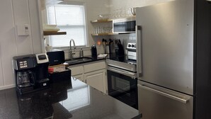 A modern kitchen with a stainless steel refrigerator, a coffee maker, a stove, and a sink. - BEECH MOUNTAIN HIGH - WALK TO SLOPES! (Beech Mountain, NC)