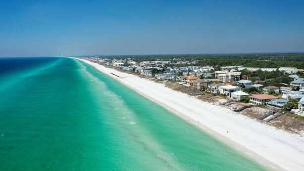 An aerial view of a coastal town with a long stretch of beach and residential buildings along the shore. -  Private Beach Access l CONVENIENCE: 2 minute walk to the Beach! (Santa Rosa Beach)