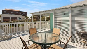 A covered outdoor patio with a glass table and chairs, a barbecue grill, and a white fence. -  Private Beach Access l CONVENIENCE: 2 minute walk to the Beach! (Santa Rosa Beach)