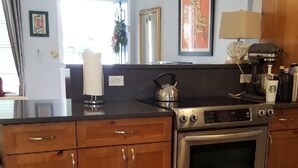 Una cocina con armarios de madera, horno de acero inoxidable y cafetera.