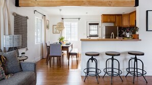 Eine moderne Küche mit Holzschränken, einem Edelstahlkühlschrank und einer Bar mit Hockern.