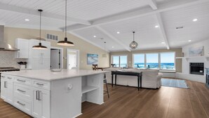 A spacious kitchen with white cabinetry, a large island, and pendant lighting. - My Island Pad: Beachfront Home, Fully Renovated (Pensacola Beach)