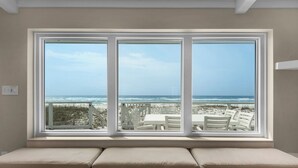 A room with a large window overlooking a beach. - My Island Pad: Beachfront Home, Fully Renovated (Pensacola Beach)