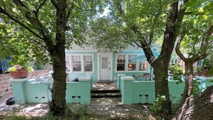 Una casa con portico, un piccolo giardino e una cassetta delle lettere.