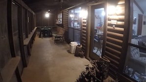 A corridor with wooden walls, a bench, a table, and chairs.