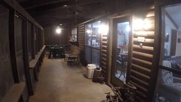 A corridor with wooden walls, a bench, a table, and chairs.