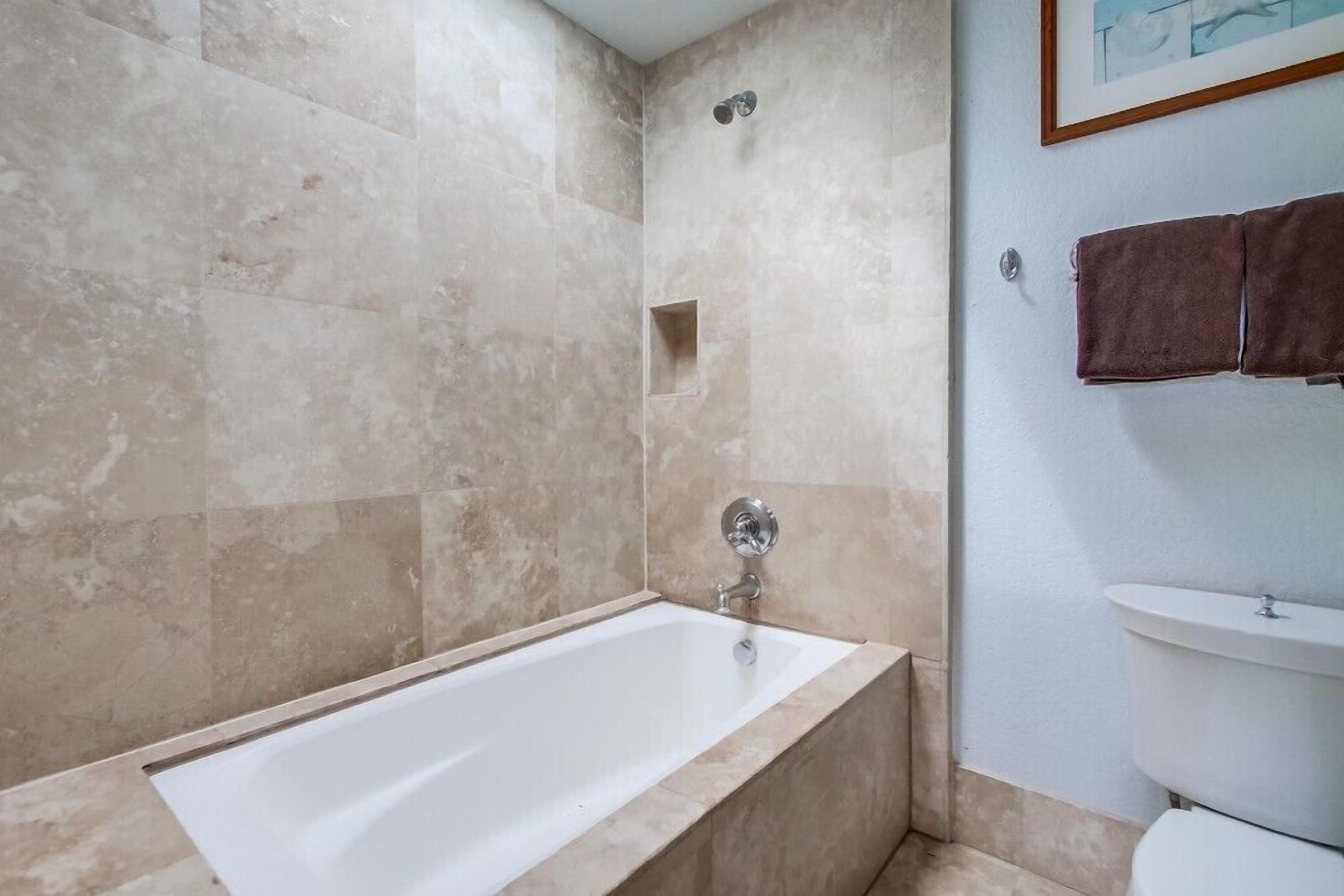 A bathroom with a bathtub, a shower, and a toilet.