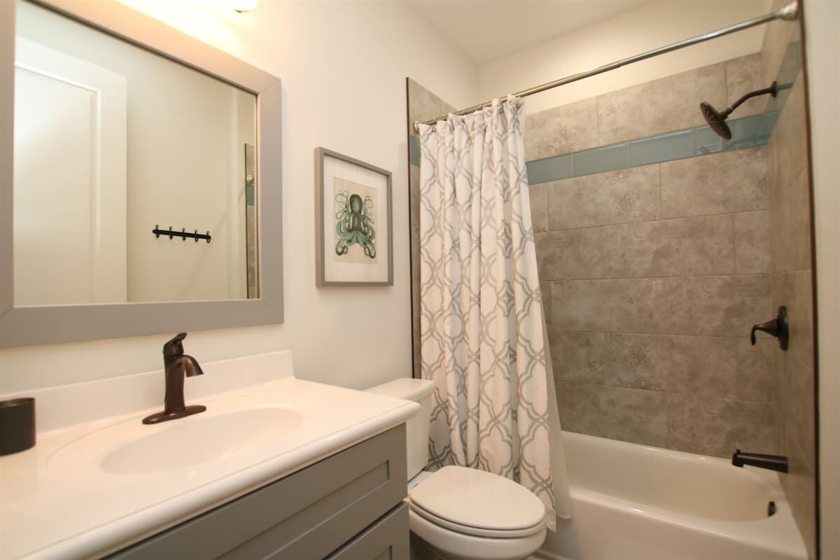 A bathroom with a sink, toilet, and bathtub.