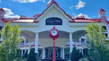 A large building with a prominent clock and the sign "River Walk Resort at El Paso Mission".