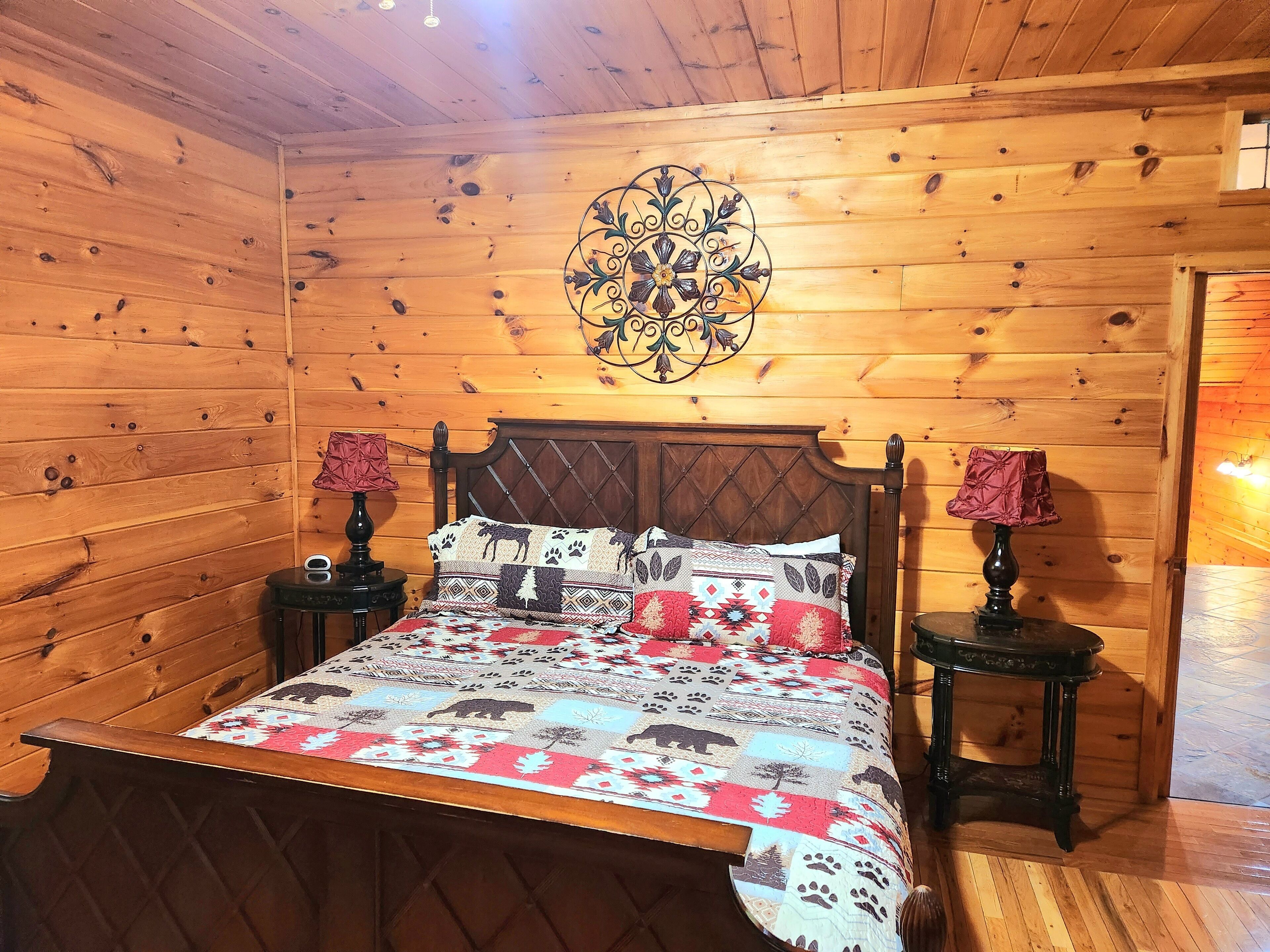Une pièce en bois comprenant un lit, deux tables de chevet et un élément décoratif mural.