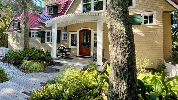 A two-story house with a red roof, a porch, and a front door. - "Tupelo Honey" New Upscale Home With Magnificant Golf Course Views; screened in porch (Bald Head Island)