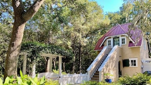 A house with a red roof, a wooden deck, and a white fence. - "Tupelo Honey" New Upscale Home With Magnificant Golf Course Views; screened in porch (Bald Head Island)